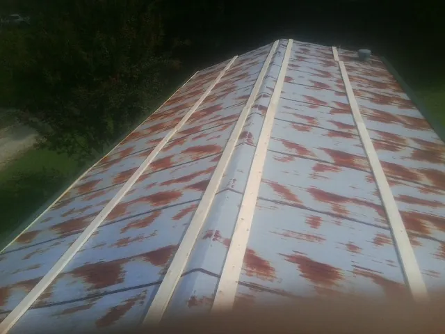 Rusted metal roof panels with new wood purlins before replacement — Storm Damage Roof Repair in Wilmington by Roofing Brothers
